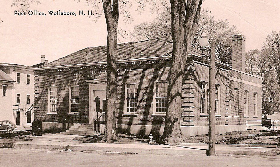 A sepia tone photograph of the Wolfeboro Post Office shaded by large trees