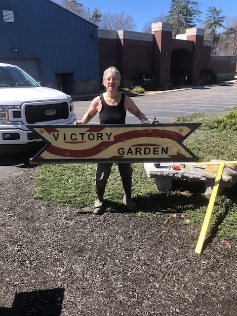 Volunteer Chrisy holding Victory Garden sign