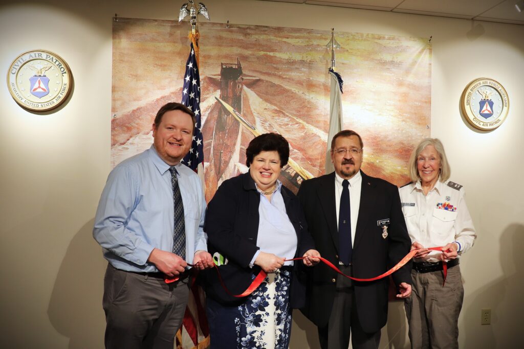 Members of the Wright Museum Staff and CAP pose for a group photo holding up the ribbon after officially opening the exhibit